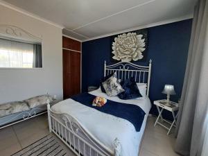 Brakpan@ Home Bed & Breakfast的卧室配有白色床和蓝色的墙壁