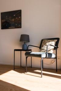 波鸿FeelsLikeHome - Traumhafte zentrumsnahe Wohnung mit Balkon&Parkplatz的椅子,带灯和桌子的房间