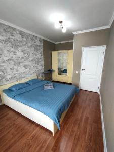 奇姆肯特2 комнатная Нурсат вдоль Аллеи的一间卧室配有一张带蓝色棉被的床