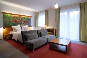 科希切日纳Hotel Szarlota - Kompleksowo na Kaszubach的客厅配有沙发和1张床