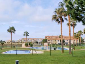 圣乔治Panoramica Golf Karilo的棕榈树公园和游泳池