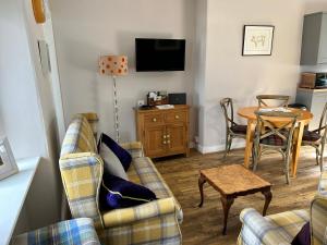 RhynieLottie’s Cottage, Rhynie, Aberdeenshire的客厅配有两张沙发和一张桌子