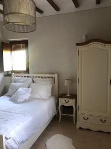 拉瓦利德维亚尼亚Masia Quelet的一间卧室配有一张带白色床单和一盏灯的床。