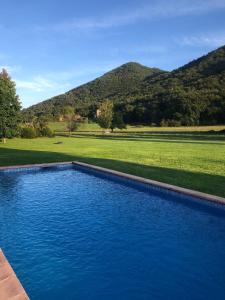 拉瓦利德维亚尼亚Masia Quelet的一座蓝色的游泳池,后面是群山