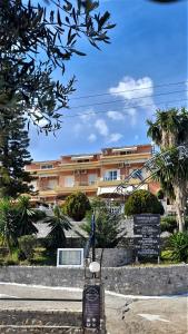 巴尔巴蒂Stefanosplace ApartHotel Sea View的棕榈树建筑前的标志