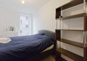 伦敦2-Bed Apartment only 15 mins from Central London的一间卧室设有一张床和一个书架