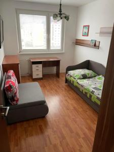 Kysucké Nové MestoApartman Gufo的一间卧室配有一张床、一张沙发和一张桌子