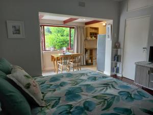 开普敦Sunshine Cottage的一间带一张床的客厅和一间带桌子的厨房