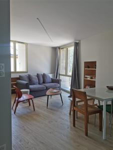 维拉尔-德朗Villard de Lans, coeur de village.Bel appartement的客厅配有蓝色的沙发和桌子