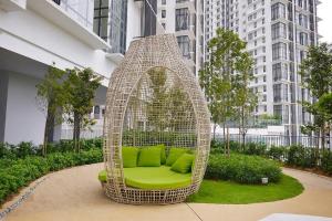 塞贝维Cyberjaya Eclipse 5 Plus 2 PAX Blissful Suite的庭院里配有藤椅和绿色枕头