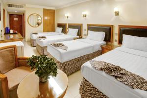 亚喀巴Dweik Hotel LUXURY 3的酒店客房设有三张床和一张桌子