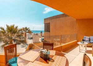 普拉亚登博萨Amazing seafront apt in playa den bossa的阳台配有桌子,享有海景。