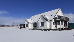 OseAchalochan House的雪地顶上的白色房子