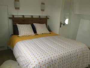 卡斯特尔萨拉桑Péniche GEMJO的一间卧室配有一张黄色和白色的被子。