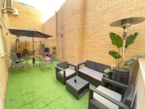 格拉纳达Futurotel Space Spa Garden的一个带绿草和椅子及遮阳伞的庭院