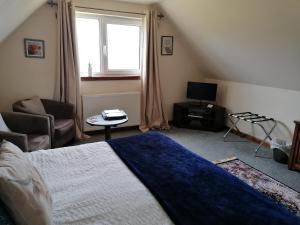 波特里Balmoral Skye的一间卧室设有一张床、一台电视和一个窗口。