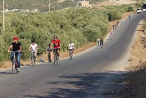乌姆盖斯Baiet AL-Deafah Guest house的一群人骑着自行车沿着马路