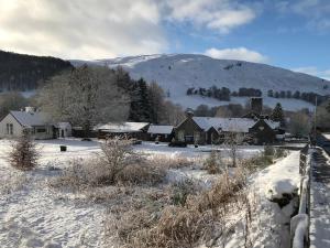 布莱尔阿瑟尔Dalgreine Guest House的一座有房子和山的雪覆盖的村庄