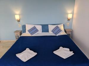弗朗哥卡斯特隆珊瑚旅馆的一间卧室配有蓝色的床和毛巾