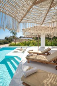 阿斯格罗Gatsby Rhodes-Brand New Seaview Villa的一个带椅子和遮阳伞的游泳池的度假酒店