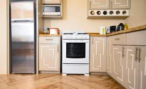 金斯敦Royal Bliss Apartment Suites的厨房配有白色炉灶和冰箱。