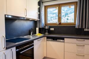 上施陶芬Thaler Höhe的厨房配有白色橱柜、水槽和窗户。