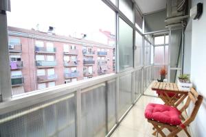 格拉诺列尔斯Nice new apartment only 30min to Barcelona center.的阳台配有桌椅和大窗户。