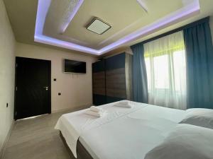 Tserova KoriyaКъща за гости ЕМ Парадайс的卧室配有一张白色大床和电视。