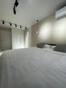 巴甫洛达尔Nursultana Nazarbaeva 20 Str by Slissenko Inn的卧室配有一张带两个枕头的大白色床