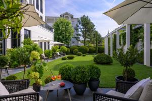 宾茨A-ROSA Collection Hotel Ceres am Meer的户外庭院设有椅子和种有植物的草坪。