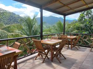 Marigot多米尼加宁静小屋酒店的庭院配有桌椅,背景为山脉