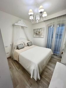 伊斯基亚Maison Mele Ischia的白色卧室配有白色的床和吊灯