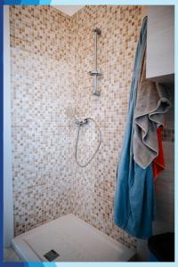 圣伊西多罗Casa Vacanza La Torre的浴室内配有蓝色淋浴帘