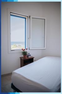 圣伊西多罗Casa Vacanza La Torre的卧室配有白色的床和2扇窗户。