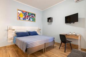 丽都迪奥斯蒂亚RomeCookSea Guesthouse的一间卧室配有一张床、一张书桌和一台电视
