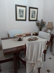考瑙皮迪亚纳Casa Matzurana的餐桌、白色桌布和椅子