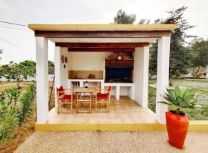 Sant Francesc de s'EstanyBonita Casa con piscina privada y amplio jardin的一个带桌椅的小凉亭