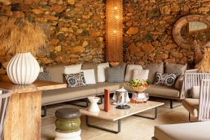 圣弗洛朗Hôtel La Dimora & Spa的带沙发和石墙的客厅