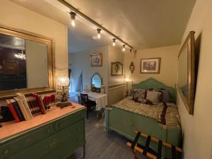 卡拉马祖亨德森城堡住宿加早餐旅馆的一间卧室配有一张绿色的床和一张带镜子的书桌