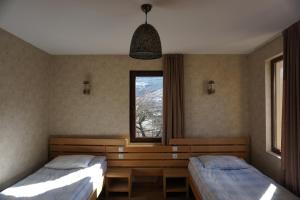 梅斯蒂亚Mestia Panorama的一间卧室设有两张床和窗户。