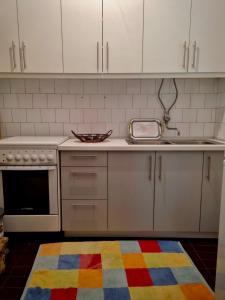 StolacVilla Tajra Stolac的厨房配有白色橱柜和色彩缤纷的地毯。