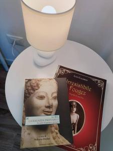 塔兰托B&B Casa Alinella, Happy and Sustainable Hospitality的一本书和一张白板上的蜡烛