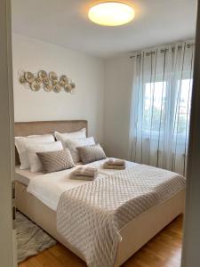 里耶卡Portview apartment的一间卧室配有一张带白色床单的床和一扇窗户。