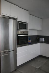 纳萨雷特Villa Darío en Nazaret的厨房配有不锈钢冰箱和微波炉。