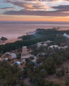 Qaşr GhīlānHotel Pansy的享有树木繁茂的海滩和大楼的空中景致