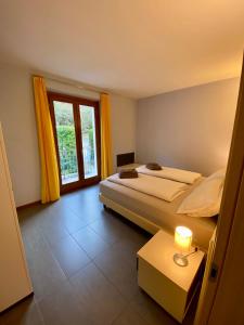 坎诺比奥Marenca Residence的一间卧室设有两张床和窗户。