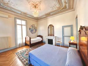 尼斯Résidence La Villa Léonie的一间卧室配有一张床和一个壁炉