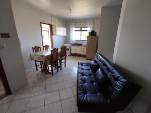 瓜尔达恩巴Residencial Medeiros的客厅配有黑色真皮沙发和桌子