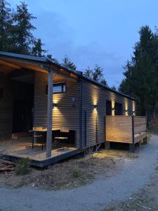 埃京Modernes Tinyhouse Trailer Cabins am Waldrand - mit Seezugang的小屋设有木甲板和桌子