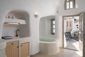 梅加洛克里Nisó Cave Suites的带浴缸和盥洗盆的浴室